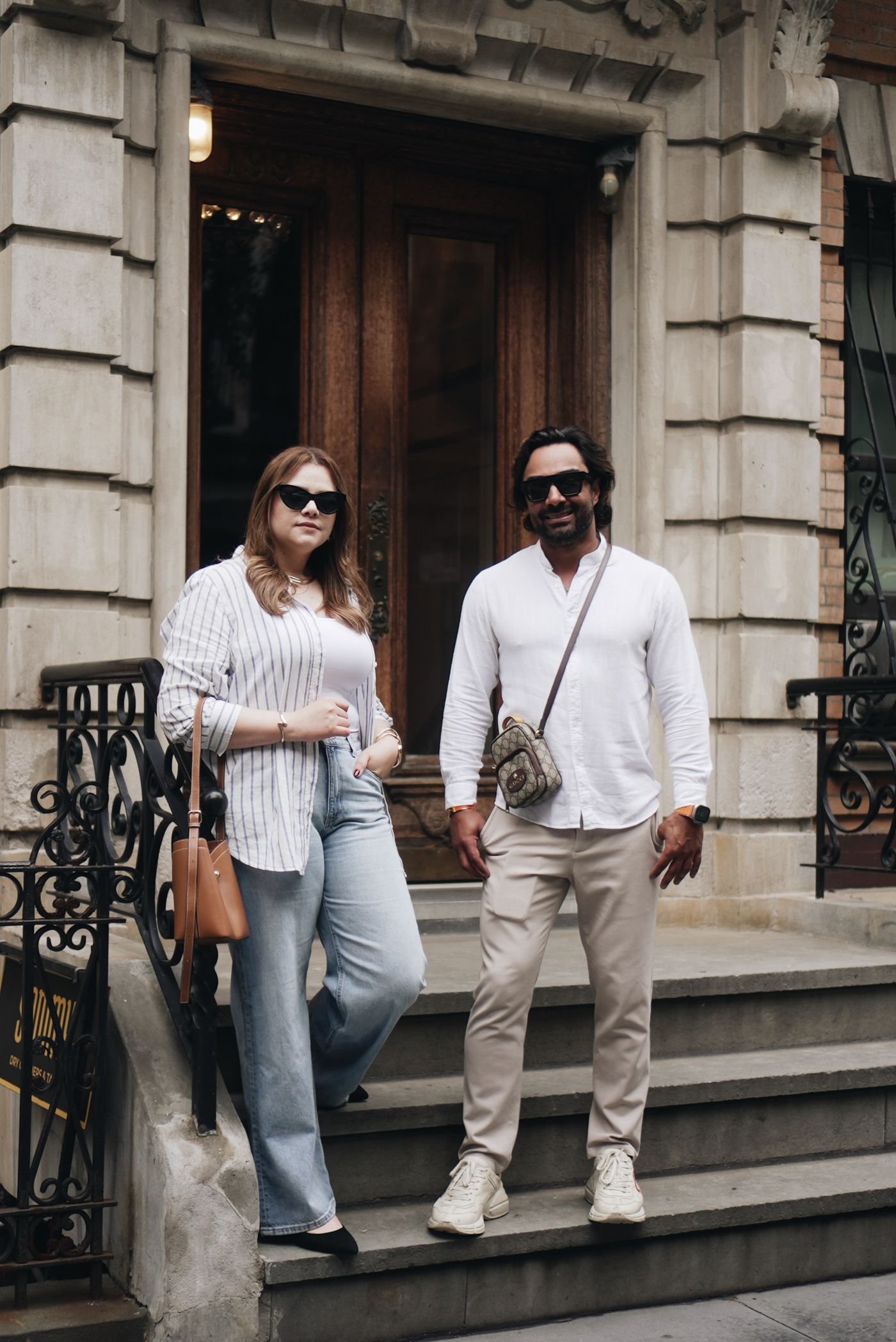 Thais Silva and Alexandre Gironde on the steps of a brownstone